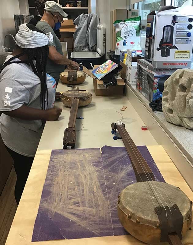 Ashley (student) and Sule (instructor) finish building their gourd banjos at a BBRP class in 2021. 